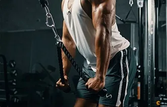 An athlete mid-set on a cable machine, performing a triceps pushdown